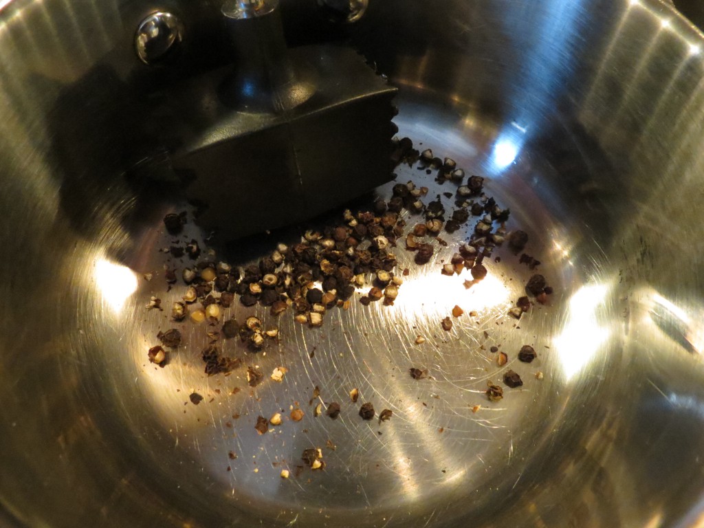 I used my meat tenderizer to crack my peppercorns directly in the saucepan.  You could also use a mortar and pestle, or place the peppercorns in a plastic bag and bash them with a rolling pin or heavy can.