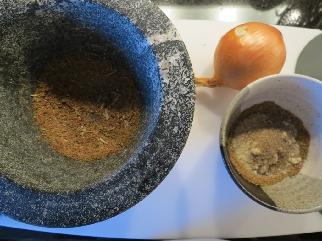 On the left are the whole spices that have been ground, and on the right is the finishing nut/spice mixture of coriander, salt, garam masala, pepper, fennel and almonds.  The onion sits happily nestled in between the two spice bowls, awaiting its chopping.