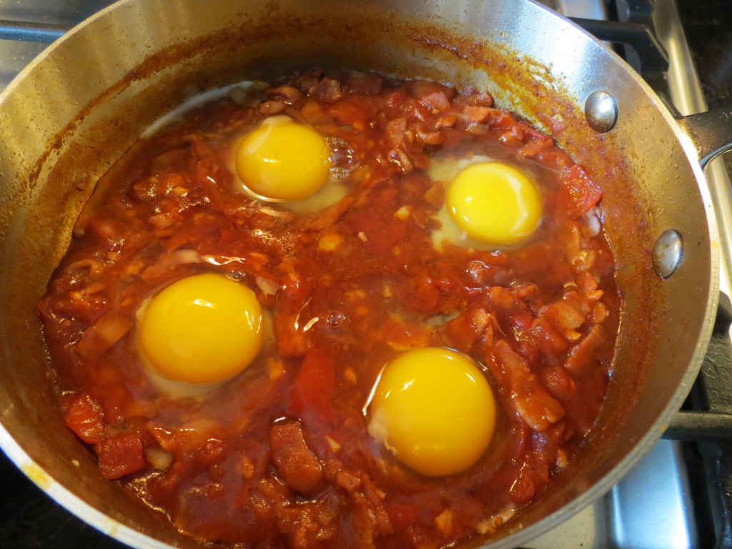 I made small divots in the sauce just before cracking each egg, so that each egg would remain reasonably intact once in the skillet.