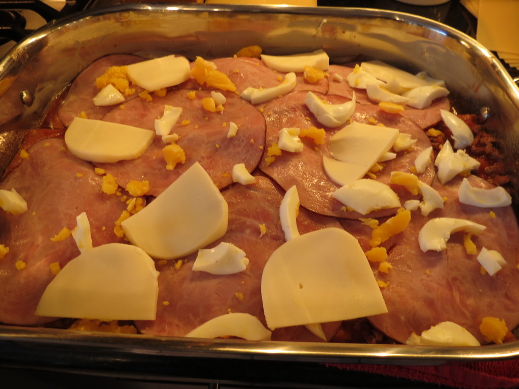 Layers of dried pasta sheets (the extra runny sauce will cook the noodles in the oven, magically), lots of ham, a bit of cheese, and some hard boiled eggs make this taste fantastic.  Trust me.